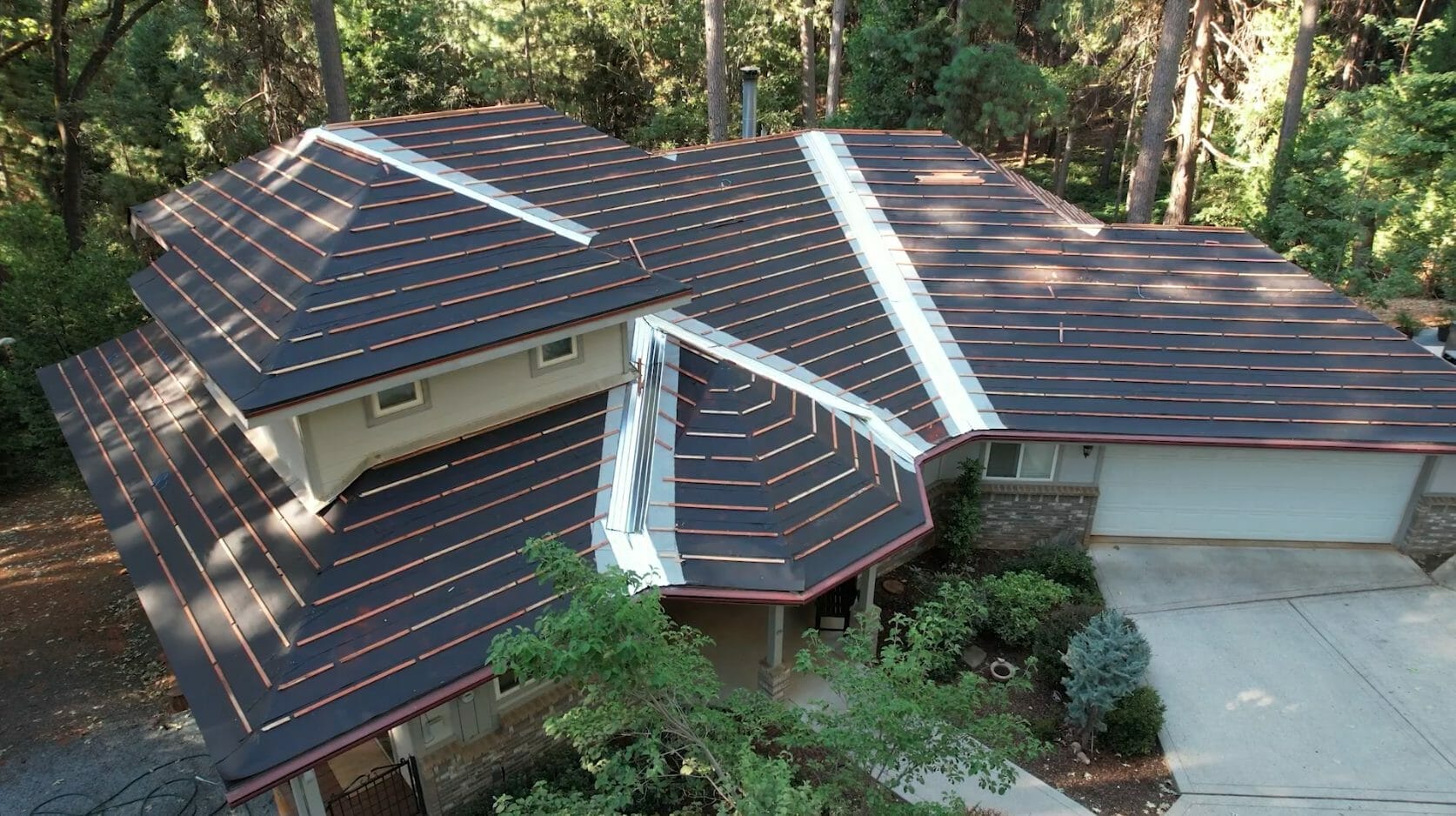 Aerial view of home with dark metal roof